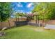 Charming backyard pergola with a built-in bench, lush greenery, and artificial turf for easy maintenance and enjoyment at 1634 W Red Bird Rd, Phoenix, AZ 85085