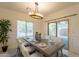 Dining area featuring a modern chandelier, a window with natural light, and sliding glass doors to the outside at 1634 W Red Bird Rd, Phoenix, AZ 85085