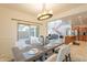 Bright dining room with modern chandelier and open floor plan to living area and backyard access at 1634 W Red Bird Rd, Phoenix, AZ 85085