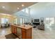 Open kitchen with island, granite countertops, and stainless steel appliances flowing into a naturally lit living room at 1634 W Red Bird Rd, Phoenix, AZ 85085