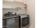 Functional laundry room features modern washer and dryer, with storage shelves for convenience at 1634 W Red Bird Rd, Phoenix, AZ 85085