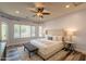 Bright bedroom featuring a ceiling fan, large windows, and a comfortable seating area at 1634 W Red Bird Rd, Phoenix, AZ 85085