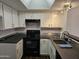 Bright kitchen featuring white cabinets, dark countertops, and stainless-steel sink at 1720 E Thunderbird Rd # 2087, Phoenix, AZ 85022