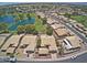 Aerial view showcasing a well-maintained community with lush landscaping, a golf course, and a serene lake at 17224 N Zuni Trl, Surprise, AZ 85374