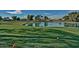 Scenic golf course with a large pond, manicured green, and mature trees in a residential community at 17224 N Zuni Trl, Surprise, AZ 85374
