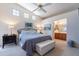 Cozy main bedroom featuring plush carpeting, a ceiling fan, and convenient access to the adjacent bathroom at 17224 N Zuni Trl, Surprise, AZ 85374