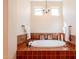 Inviting primary bathroom soaking tub featuring elegant chandelier and decorative tile surround at 1787 E Sattoo Way, Queen Creek, AZ 85140