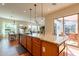 Well-appointed kitchen with a center island, barstool seating, stainless steel appliances, and an adjacent dining area at 1787 E Sattoo Way, Queen Creek, AZ 85140