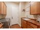 Functional laundry room with a sink, wooden cabinets, and a modern washer/dryer set at 1787 E Sattoo Way, Queen Creek, AZ 85140