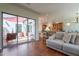 Bright living room featuring a comfortable sofa, tile floors and seamless flow to an outdoor patio at 1787 E Sattoo Way, Queen Creek, AZ 85140