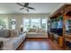 Bright living room with a plush sectional sofa, large windows, and a ceiling fan at 1787 E Sattoo Way, Queen Creek, AZ 85140