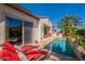 Backyard patio featuring a pool, lounge chairs, lush tropical landscaping, and view of the rear of the home at 1787 E Sattoo Way, Queen Creek, AZ 85140
