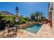 Backyard pool with lush tropical landscaping, lounge chairs, patio seating, and travertine stone decking at 1787 E Sattoo Way, Queen Creek, AZ 85140