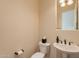 Charming powder room with pedestal sink, toilet, and mirror, ideal for guests at 1787 E Sattoo Way, Queen Creek, AZ 85140