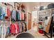 Spacious walk-in closet with custom shelving, hanging racks, and a central ottoman for dressing at 1787 E Sattoo Way, Queen Creek, AZ 85140