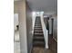 Carpeted staircase with white painted railing leads to second level of home at 1810 N Mcdonald St, Casa Grande, AZ 85122
