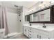 Bright bathroom features double sinks, black fixtures, and a shower-tub combo with white tile at 1829 E Decatur St, Mesa, AZ 85203