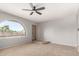 Bright bedroom with neutral carpet, a fan, and an arched window at 1829 E Decatur St, Mesa, AZ 85203