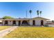 Charming single-story home featuring a lush lawn, arched windows, and inviting curb appeal at 1829 E Decatur St, Mesa, AZ 85203