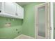 Laundry room with storage cabinets, hookups, and a glass-paned pantry door at 1829 E Decatur St, Mesa, AZ 85203