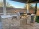 Built-in outdoor grill and kitchen area with stone accents and ample counter space at 2351 E Cherrywood Pl, Chandler, AZ 85249