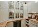 Walk-in pantry featuring glass-front cabinets, wooden countertops, and built-in wine refrigerator at 2351 E Cherrywood Pl, Chandler, AZ 85249