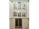 Close-up of a well-organized pantry with glass-front cabinets and a built-in wine cooler at 2351 E Cherrywood Pl, Chandler, AZ 85249
