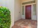 Charming covered front porch features vibrant bougainvillea and a stylish maroon door with transom windows at 2552 E Silverwood Dr, Phoenix, AZ 85048