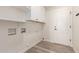 Well-lit laundry room with ample shelving, modern flooring, and convenient washer/dryer hookups at 2552 E Silverwood Dr, Phoenix, AZ 85048