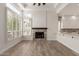 Living room featuring a brick fireplace, wood-look flooring, and white paint at 2552 E Silverwood Dr, Phoenix, AZ 85048