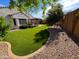 Landscaped backyard features manicured lawn, pergola with patio seating, and rock landscaping at 25935 W Potter Dr, Buckeye, AZ 85396