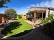 Well-manicured backyard with lawn, rock features, pergola with seating, and a covered patio at 25935 W Potter Dr, Buckeye, AZ 85396