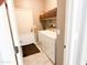 Well-lit laundry room with a full-size washer and dryer and a storage shelf above the appliances at 25935 W Potter Dr, Buckeye, AZ 85396