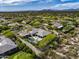 Expansive aerial view of desert home featuring a pool, putting green, mature landscaping, and mountain views at 26099 N 88Th Way, Scottsdale, AZ 85255