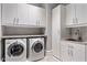 Laundry room featuring new appliances, overhead cabinets, and a sink basin at 26099 N 88Th Way, Scottsdale, AZ 85255