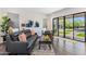 Bright living room with a stylish sofa, modern artwork, and large sliding doors leading to an outdoor pool at 26099 N 88Th Way, Scottsdale, AZ 85255