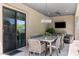 Covered outdoor dining area featuring a large table, seating, and a mounted television, perfect for entertaining and relaxation at 26099 N 88Th Way, Scottsdale, AZ 85255