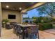 Covered outdoor dining area with a large table, ceiling fan, and TV for al fresco entertainment at 26099 N 88Th Way, Scottsdale, AZ 85255