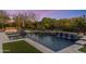 Beautiful pool with a spa and water feature surrounded by lush landscaping and an outdoor fireplace area at 26099 N 88Th Way, Scottsdale, AZ 85255
