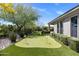 Enjoy a backyard putting green with mature landscaping, stone accents, and privacy hedges around the property at 26099 N 88Th Way, Scottsdale, AZ 85255