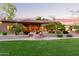 Expansive backyard with mature trees, lush green grass, and meticulous landscaping for an outdoor oasis at 2641 E Birchwood Pl, Chandler, AZ 85249