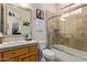 Bathroom featuring neutral walls, wood cabinets, tile surround and glass shower at 2641 E Birchwood Pl, Chandler, AZ 85249
