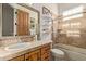 Bathroom featuring tile surround, frameless glass shower, wood cabinets and shelving for storage at 2641 E Birchwood Pl, Chandler, AZ 85249