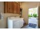 Functional laundry room with washer, dryer, storage cabinets, and convenient outdoor access at 2641 E Birchwood Pl, Chandler, AZ 85249