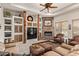 Comfortable living room with stone fireplace, custom shelving, and comfortable leather seating at 2641 E Birchwood Pl, Chandler, AZ 85249