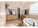 Luxurious main bathroom with dual vanities, tile floor, and a soaking tub at 2641 E Birchwood Pl, Chandler, AZ 85249