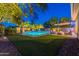 Stunning backyard at dusk featuring a pool, fire pit, and comfortable seating area at 26879 N 100Th Ln, Peoria, AZ 85383