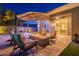 Relaxing backyard featuring a fire pit, comfortable seating, and a covered outdoor area at 26879 N 100Th Ln, Peoria, AZ 85383