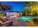Inviting outdoor space with a sparkling pool, lush greenery, and comfortable seating at 26879 N 100Th Ln, Peoria, AZ 85383