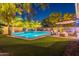 Backyard patio area with fire pit, lush landscaping and a refreshing pool with water feature at 26879 N 100Th Ln, Peoria, AZ 85383